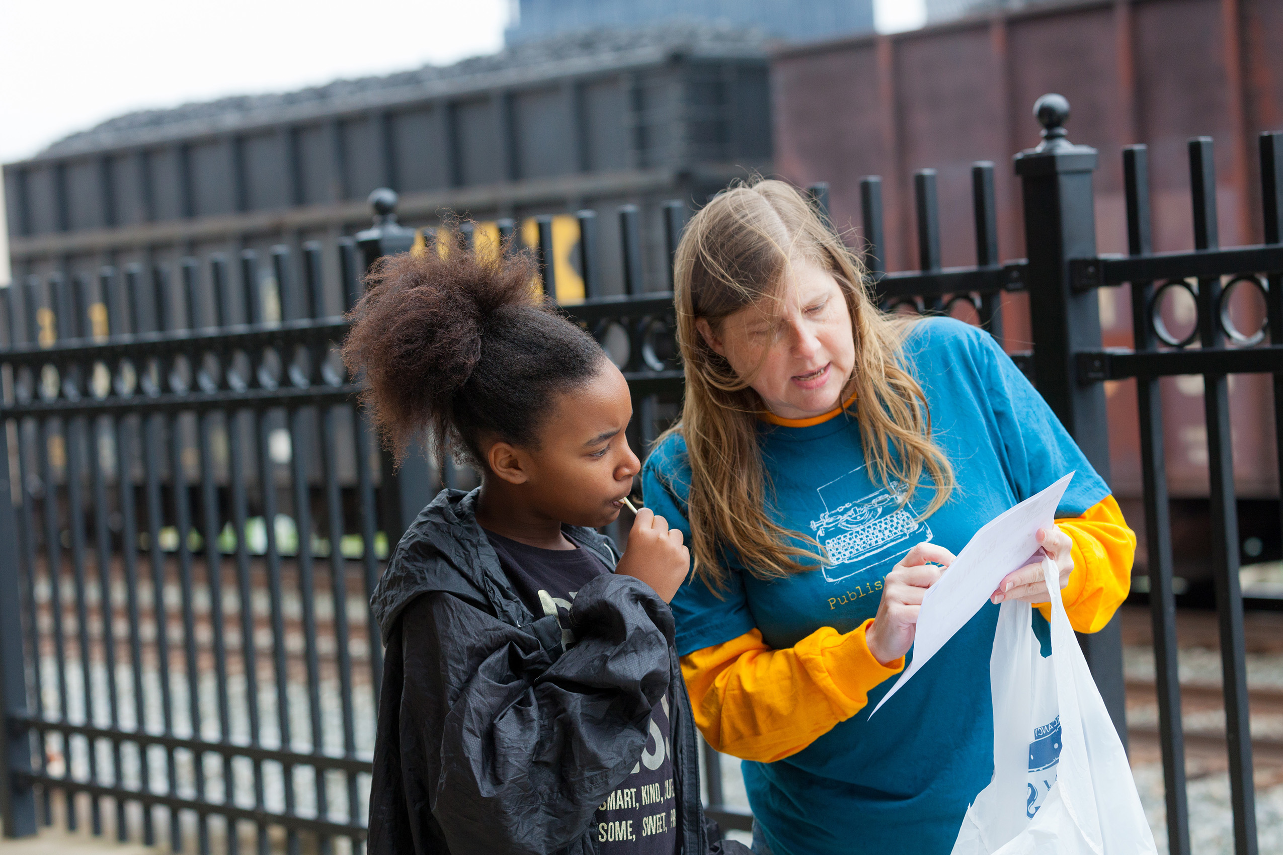 A teacher showing a child something on a piece of paper.