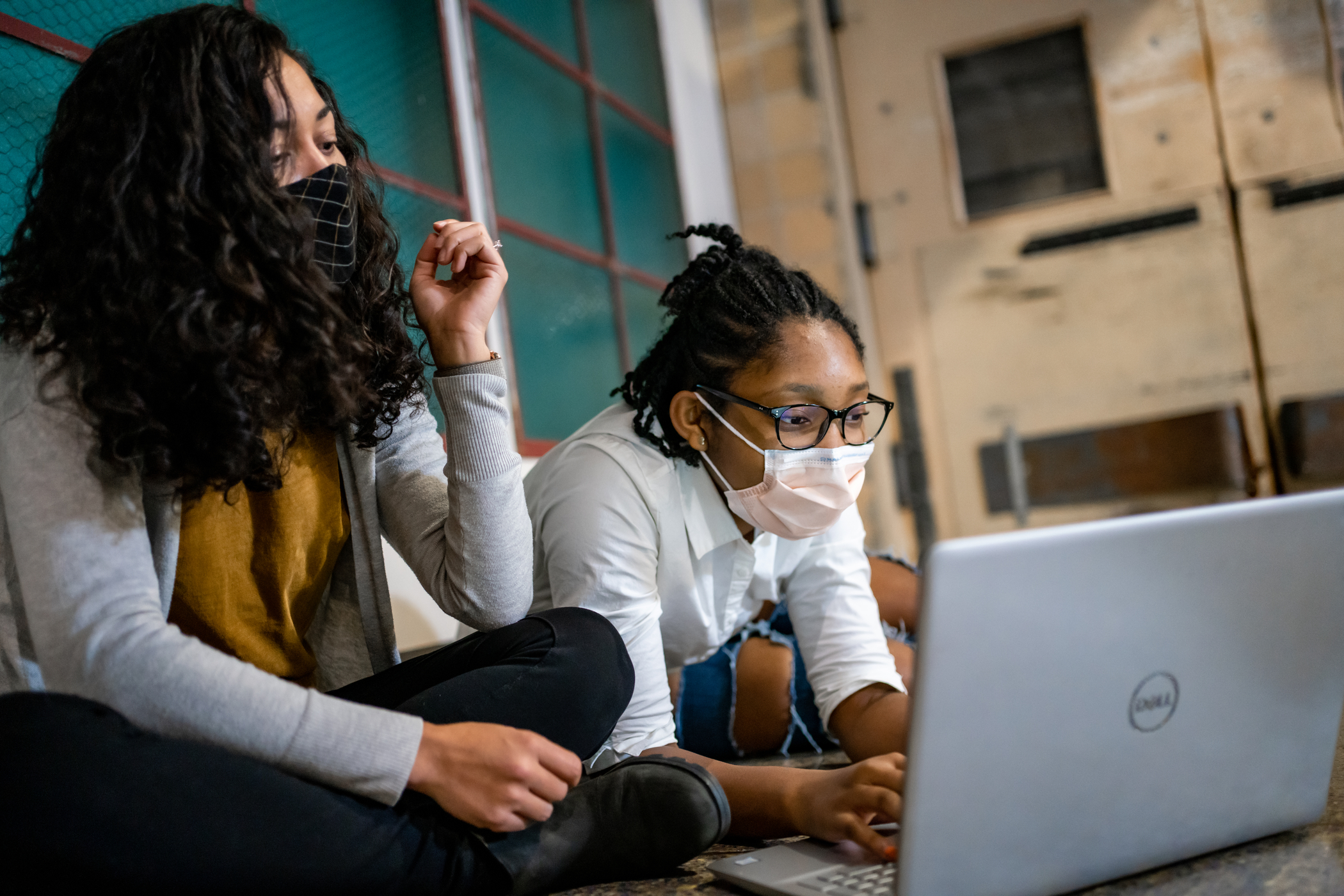 A teacher and a student looking at a computer.