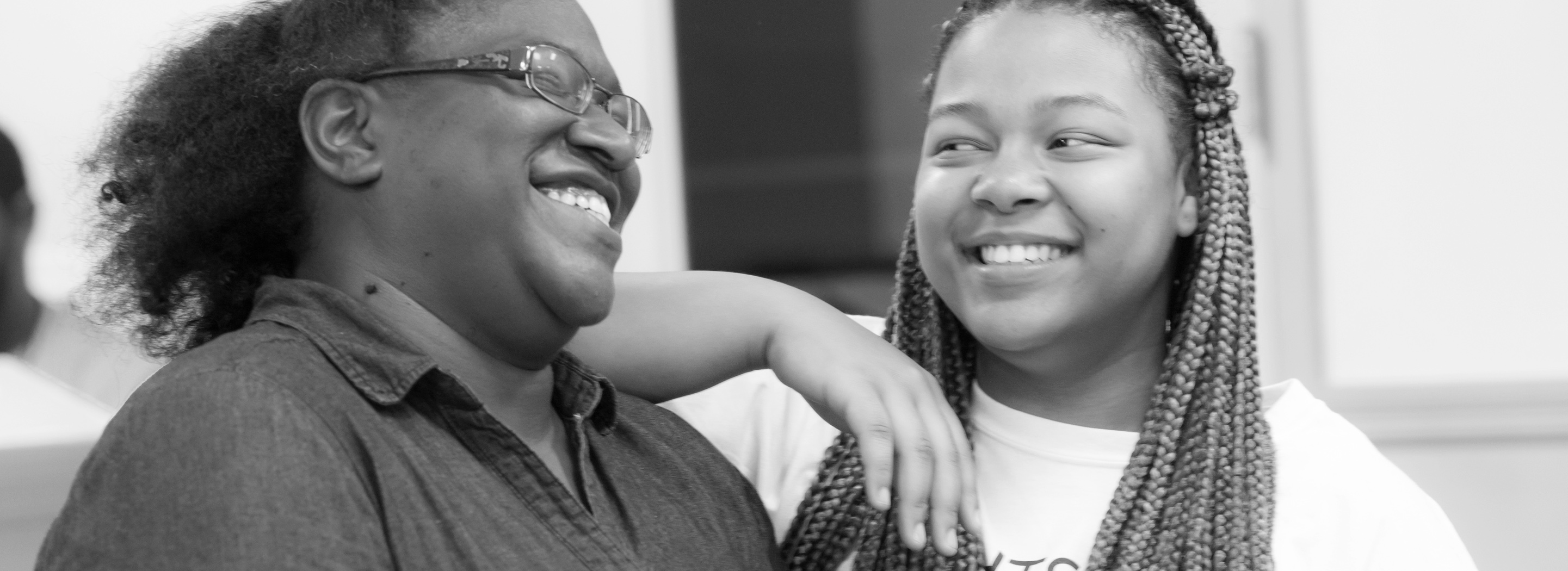 A woman laughing with a teen.